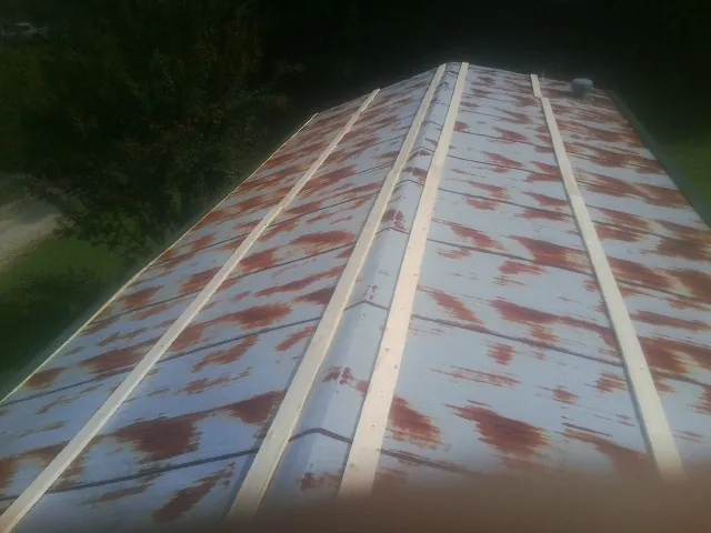 Rusted metal roof panels with new wood purlins before replacement — Storm Damage Roof Repair in Loudonville by Roofing Brothers