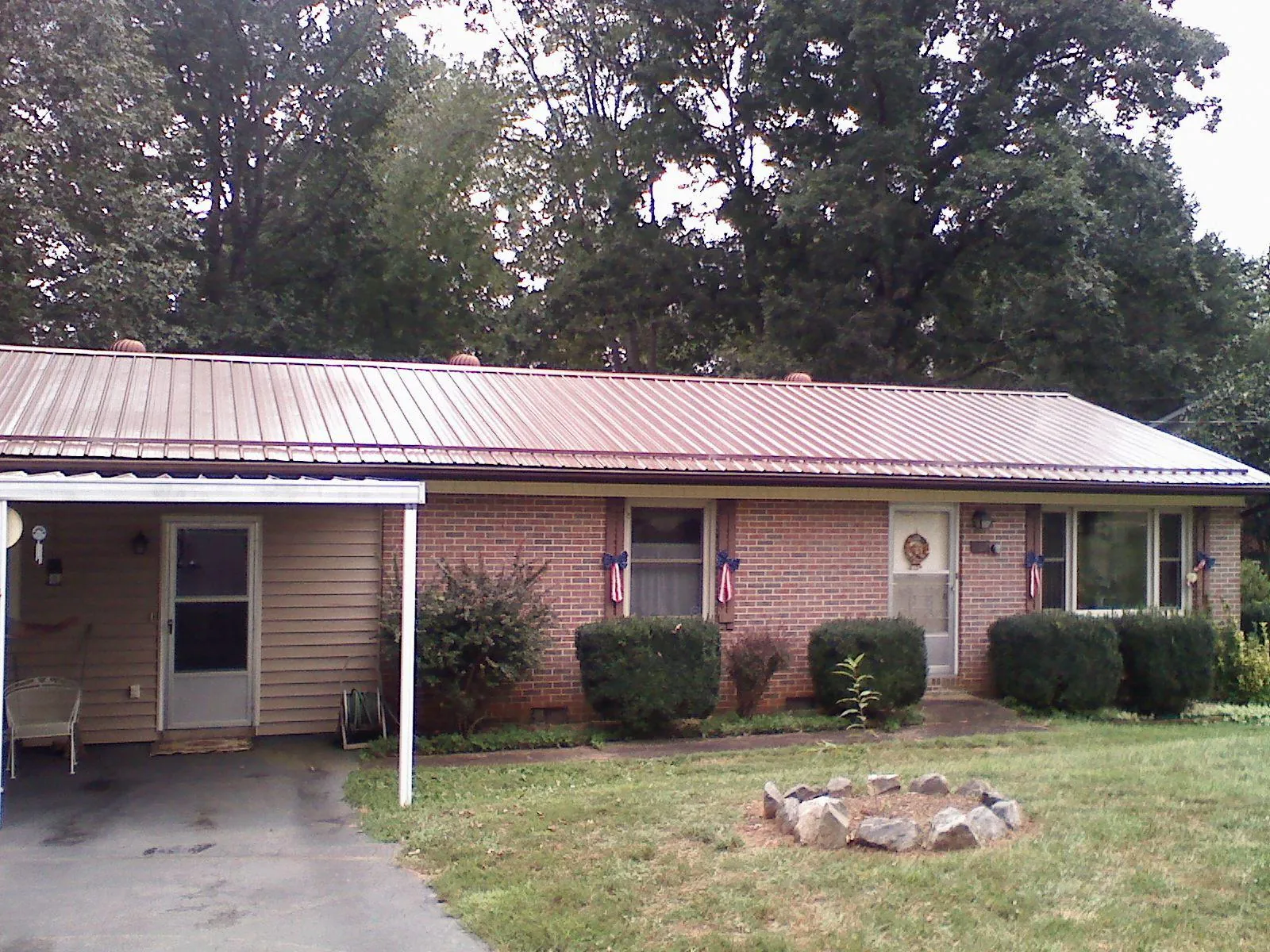 Bronze metal roof and carport on a brick ranch home — Roof Repair work by our crew in Loudonville